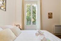 a white bedroom with two beds and a window at 2 pièces tout confort, déco moderne, wifi fibre in Grenoble