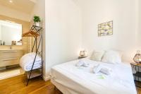 a small bedroom with a white bed and a dresser at 2 pièces tout confort, déco moderne, wifi fibre in Grenoble