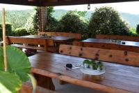 a patio with wooden benches and tables with plants at Apartman Fachin in Motovun