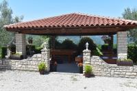 a gazebo with a table and a stone wall at Apartman Fachin in Motovun