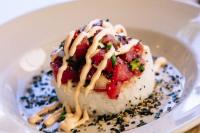 Un trozo de comida en un plato con arroz y salsa. en Aston Kaanapali Shores, en Lahaina