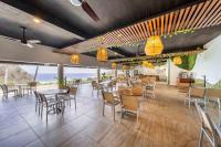 a restaurant with tables and chairs and a view of the ocean at Villas Coral Huatulco in Santa Cruz Huatulco