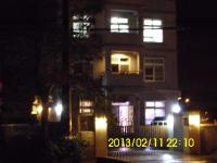 a lit up house with a balcony at night at Xinchuan B&amp;B in Dayi