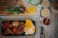 Un plato de desayuno con huevos, carne y maíz. en Mandala Ace Albany Hotel, en Albany