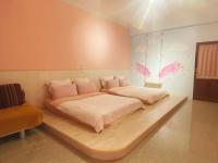 a bedroom with two beds and a chair at Hualien Lidu House in Hualien City