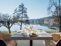una mesa con comida y vistas al lago en Werzers Hotel Resort Pörtschach, en Pörtschach am Wörthersee