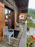 a wooden deck with two chairs and a table at APPARTEMENT PLEIN SUD AUX SAISIES N°6 in Les Saisies