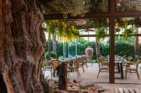 トレビエハにあるHotel La Laguna Spa & Golfのテーブルと椅子と木のあるパティオ