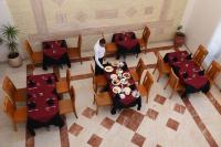 a man is standing at a table in a restaurant at Golden Beach Appart'hotel in Agadir