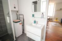 a white bathroom with a sink and a shower at Le Pastel - grand studio rénové in Angoulême