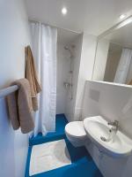 a bathroom with a white toilet and a sink at Auberge des Plaines - Appartements avec terrasse in Arles