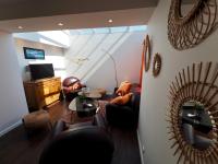 a living room with leather furniture and a mirror at 30 m des Plages - Port du Magouër - 6 invités in Plouhinec