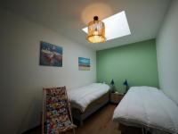 a bedroom with two beds and a chandelier at 30 m des Plages - Port du Magouër - 6 invités in Plouhinec