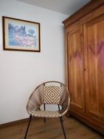 a rattan chair sitting next to a wooden cabinet at 30 m des Plages - Port du Magouër - 6 invités in Plouhinec