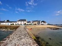 a beach with houses and the water and a road at 30 m des Plages - Port du Magouër - 6 invités in Plouhinec