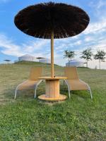 two chairs and a table with an umbrella on a field at Yurte in Langa in Bosia