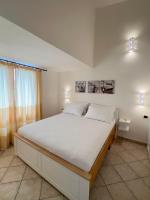A bed or beds in a room at Sardegna Costa Corallina Appartamento Luxury Vista Mare in splendido villaggio - IUN R6511