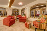 ein Wohnzimmer mit roten Möbeln und Fenstern in der Unterkunft Hotel am Schloss in Goldegg
