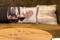 zwei Gläser Wein auf einem Holztisch in der Unterkunft Hotel am Schloss in Goldegg
