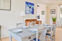 a dining room with a white table and chairs at Escapade au calme tout pres de la plage in Penmarch