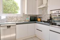 a kitchen with white cabinets and a sink and a window at Escapade au calme tout pres de la plage in Penmarch