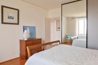 a bedroom with a white bed and a mirror at Escapade au calme tout pres de la plage in Penmarch