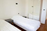 a bedroom with two beds with white sheets and a mirror at Escapade au calme tout pres de la plage in Penmarch