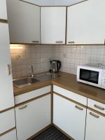 a kitchen with white cabinets and a sink and a microwave at Kieslinghof in Purbach am Neusiedlersee