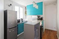 a kitchen with blue cabinets and a stainless steel refrigerator at Charming and luminous 2br with balcony - Boulogne-Billancourt - Welkeys in Boulogne-Billancourt