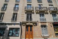 a tall brick building with windows and a door at Charming and luminous 2br with balcony - Boulogne-Billancourt - Welkeys in Boulogne-Billancourt