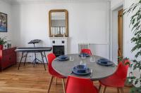 a dining room with a table and red chairs at Charming and luminous 2br with balcony - Boulogne-Billancourt - Welkeys in Boulogne-Billancourt