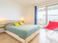 a bedroom with a bed and a red chair at Apartment Rivadour 2 by Interhome in Bayonne