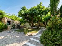 a garden with a tree and a stone path at Holiday Home Le Mas d&#39;Adélaïs by Interhome in Baron