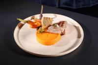 une assiette de nourriture avec de la viande et des fruits sur une table dans l'établissement Logis Hôtel Restaurant Europa, à Maussac