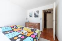 a bedroom with a bed with a colorful comforter at Appartement familial avec jardin ensoleillé dans la cité des Potiers in Vallauris