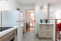 a kitchen with a white refrigerator and a table at Appartement familial avec jardin ensoleillé dans la cité des Potiers in Vallauris