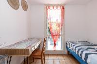 a bedroom with a bed and a desk and a window at Appartement familial avec jardin ensoleillé dans la cité des Potiers in Vallauris