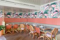 a restaurant with tables and chairs and a mural at The Ryder Hotel in Charleston