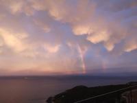 a rainbow in a cloudy sky over the ocean at Villa 10 p.Brando 170 m2 vue mer panoramique in Brando