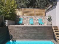 two blue chairs sitting on steps next to a swimming pool at Villa 10 p.Brando 170 m2 vue mer panoramique in Brando