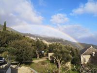 a rainbow in the sky over a village at Villa 10 p.Brando 170 m2 vue mer panoramique in Brando