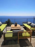 a patio with two benches and a table and the ocean at Villa 10 p.Brando 170 m2 vue mer panoramique in Brando