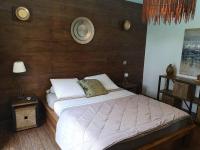 a bedroom with a bed and a wooden wall at Villa 10 p.Brando 170 m2 vue mer panoramique in Brando