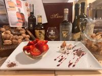 Un plato con postre sobre una mesa con botellas de vino. en Hotel Il Cavaliere Nero, en Tirrenia