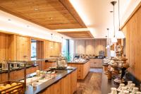 uma grande cozinha com armários e balcões de madeira em Dolomites Nature Hotel Vigilerhof em Siusi