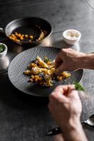 uma pessoa com um prato de comida no balcão em Dolomites Nature Hotel Vigilerhof em Siusi