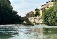 a river with a bridge and buildings in the background at Sur le Pont in Vaison-la-Romaine