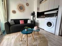 a living room with a couch and a washing machine at BARCABEACH front de mer avec terrasse et parking in Le Barcarès