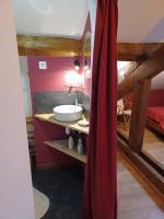 a bathroom with a sink and a red curtain at 2 chambres privées au calme à la Maison des Bambous in Dijon
