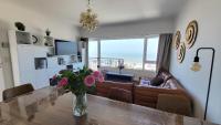 a living room with a table and a couch at SeaCityView Oostende in Ostend
